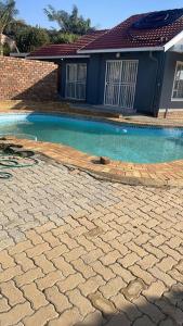 a swimming pool in front of a house at Home in Suideoord, Jhb south in Johannesburg