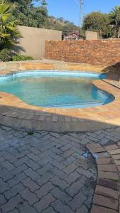 uma piscina num quintal com uma parede de tijolos em Home in Suideoord, Jhb south em Joanesburgo