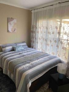 a bedroom with a large bed and a window at Home in Suideoord, Jhb south in Johannesburg +21 photos