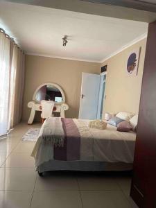 1 dormitorio con 1 cama, 1 mesa y 1 silla en Home in Suideoord, Jhb south, en Johannesburgo