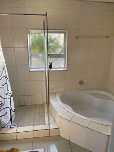 bagno con vasca e finestra di Home in Suideoord, Jhb south a Johannesburg