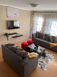 Sala de estar con 2 sofás y mesa en Home in Suideoord, Jhb south, en Johannesburgo