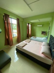 uma cama grande num quarto com paredes verdes em Homestay IJAA em Marang