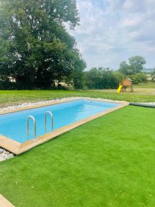 a swimming pool in a grassy yard with a slide at Logement A / Clos des Saunières in Bligny-lès-Beaune