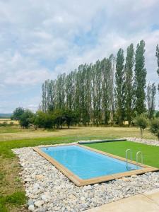 a swimming pool in the middle of a field with trees at Logement A / Clos des Saunières in Bligny-lès-Beaune