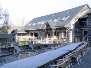 a house with a long table and chairs on a deck at Comfortable Holiday Home in Vielsalm near Lake in Vielsalm