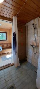 a bathroom with a shower and a shower curtain at Pulla Karvisen Maatilamatkailussa in Ruokola