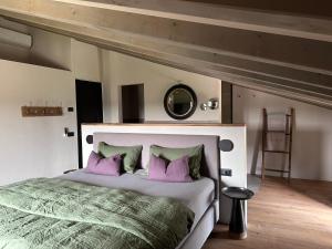 1 dormitorio con 1 cama grande con almohadas moradas en CA`NOVA AGRITURISMO, en Castellaro