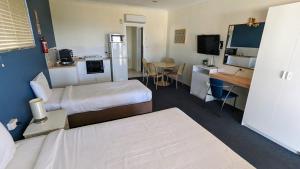 een hotelkamer met 2 bedden en een keuken bij Armidale Inn in Armidale