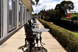 une rangée de tables et de chaises sur un trottoir dans l'établissement Armidale Inn, à Armidale