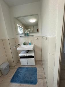 ein Bad mit einem Waschbecken und einem Spiegel in der Unterkunft Ferienwohnung am Strandbad in Friedrichshafen