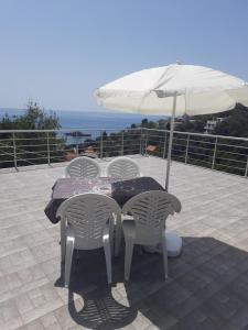 einen Tisch und Stühle unter einem Sonnenschirm auf einer Terrasse in der Unterkunft Nino Lux Apartments Ulcinj in Ulcinj