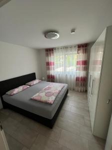 ein Schlafzimmer mit einem Bett in einem Zimmer mit einem Fenster in der Unterkunft Ferienwohnung am Strandbad in Friedrichshafen