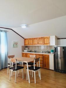 uma cozinha com uma mesa e cadeiras e um frigorífico em Seashells Home em Panglao