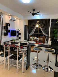 a kitchen and living room with a table and stools at Bali Residen, Mariam Indah Homestay Melaka in Melaka