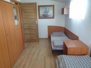 Habitación pequeña con 2 camas y puerta en Szumi domek en Kołobrzeg