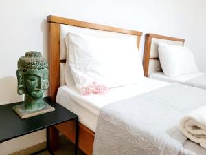 une chambre avec une statue d'une tête sur un lit dans l'établissement KORETA APARTMENT, à Vlorë