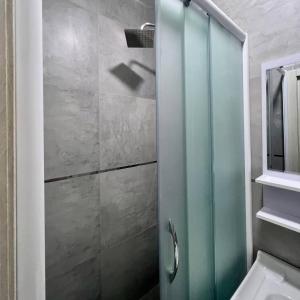 una ducha con puerta de cristal en un baño en Afsona Hotel, en Bukhara
