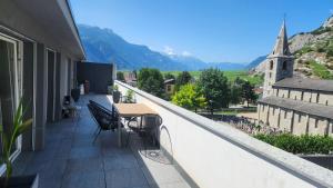 a balcony with a table and chairs and a church at Luxury Appartement de 130 m2 avec 3 chambres in Ardon