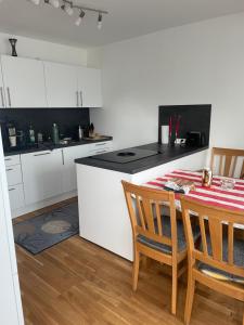 a kitchen with white cabinets and a table and chairs at Peaceful holiday in Würzburg