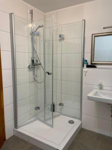 uma cabina de duche em vidro na casa de banho com um lavatório em Peaceful holiday em Würzburg