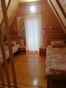 a bedroom with two beds in a log cabin at Zlatibor Brvnara Mir in Zlatibor