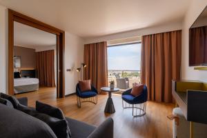 a living room with a couch and chairs and a bed at Hôtel Villa M Marseille in Marseille