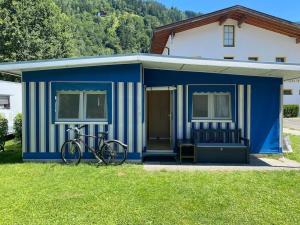 una bicicletta parcheggiata di fronte a un capanno blu di ***** Camping Aufenfeld - Sonnenglückhütte a Aschau