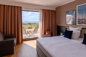 Habitación de hotel con cama y balcón en Golden Tulip Villa Massalia en Marsella