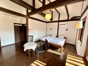 大津市にあるInase Otsu Machiya Bed and Breakfastのベッドルーム(ベッド1台、テーブル付)