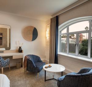Zimmer mit 2 Stühlen, einem Tisch und einem Fenster in der Unterkunft Victoria & Alfred Hotel by NEWMARK in Kapstadt