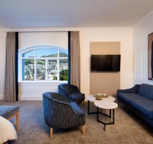 Victoria & Alfred Hotel by NEWMARK في كيب تاون: غرفة معيشة مع أريكة وطاولة