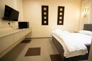 um quarto com uma cama e uma televisão de ecrã plano em HOTEL GLAMOUR IMPERIAL em Buzau
