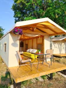 ein kleines Haus mit einer Terrasse mit einem Tisch und Stühlen in der Unterkunft Divoto Glamping in Baltschik