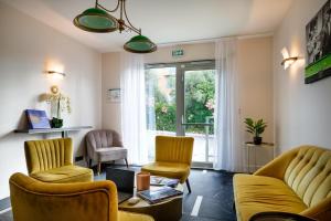 a living room with a couch and chairs and a window at Best Western Hôtel Journel Antibes Juan-les-Pins in Antibes
