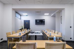 a conference room with wooden tables and chairs and a screen at Best Western Hôtel Journel Antibes Juan-les-Pins in Antibes