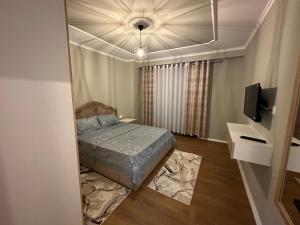 - une petite chambre avec un lit et une télévision dans l'établissement Ledio’s Luxury Apartment, à Pogradec
