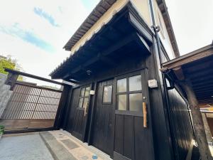 a black garage with a door and windows at Inase Otsu Machiya Bed and Breakfast in Otsu