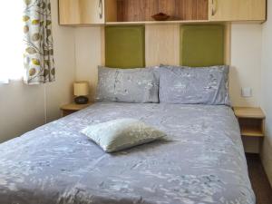 a bed with a pillow sitting on top of it at Summer Willow Lodge in Tattershall