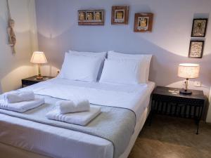 a bedroom with a large white bed with towels on it at ZeusPlace Olympus Olive Country House 1 in Leptokaria