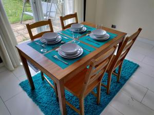 a wooden table with plates and dishes on it at Beautiful House in Ruislip in Northwood