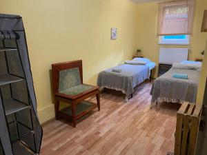 Pokój z 2 łóżkami i krzesłem w obiekcie Hostel Sielanka w Gdańsku