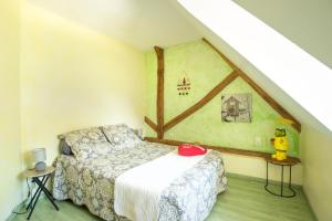 una camera da letto con letto in mansarda di La Maison du Bonheur a Saint-Martin-en-Bresse