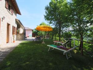 a picnic table and an umbrella in a yard at Country Cottage in Marche with Swimming Pool in Apecchio