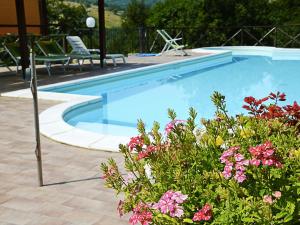 a swimming pool with flowers in a yard at Country Cottage in Marche with Swimming Pool in Apecchio