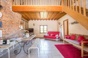 un soggiorno con un divano rosso e un tavolo di La Maison du Bonheur a Saint-Martin-en-Bresse