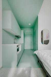 a room with green and white cabinets and a bed at New York Laisvės al 51A in Kaunas