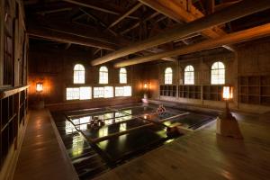 um quarto amplo com uma piscina de água num edifício em Houshi Onsen Chojukan em Minakami