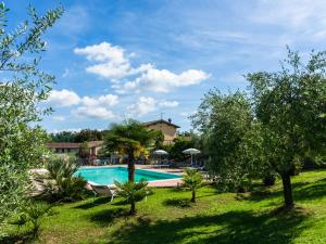 ペルージャにあるFarmhouse in Perugia with Swimming Poolの木々が植わるリゾート内のスイミングプールの景色を望めます。