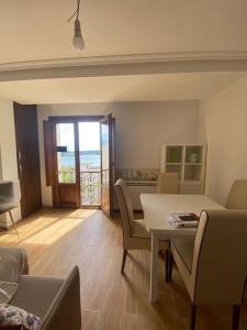 a living room with a table and chairs and a balcony at Bonito y acogedor apartamento en Castropol in Castropol